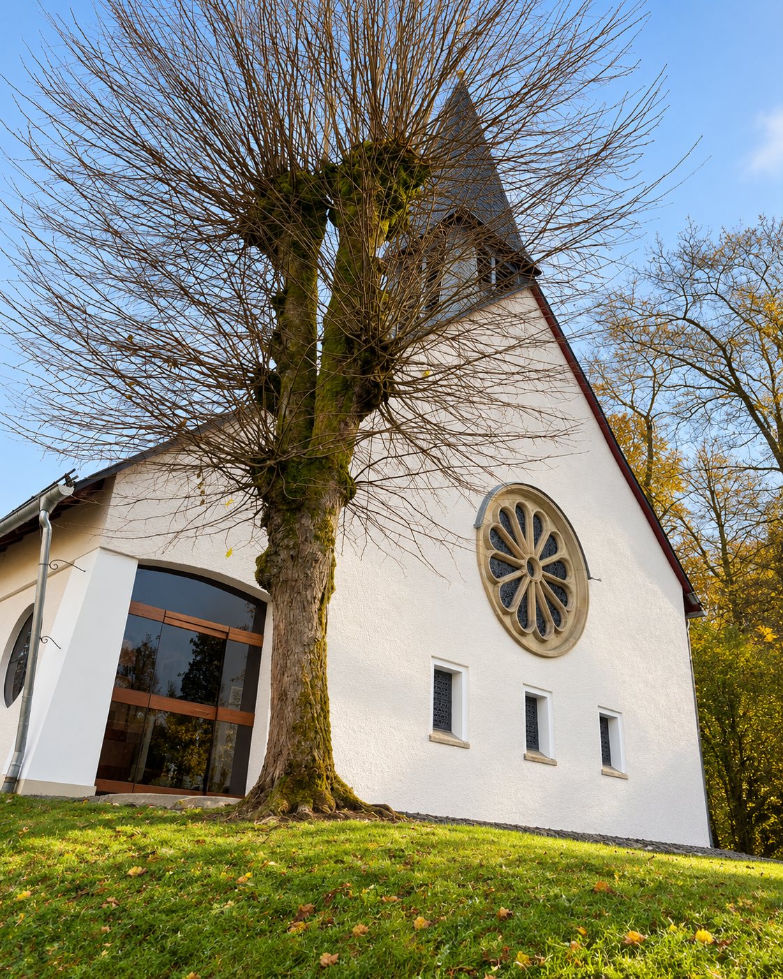 Originalaufnahme einer Referenz von Manfred Berglar, Malermeister: Kirche mit weißer Fassade und Rosettenfenster
